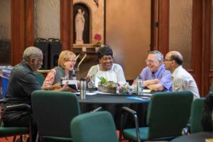 A jovial group of people sitting at a table at a Passionist retreat center.