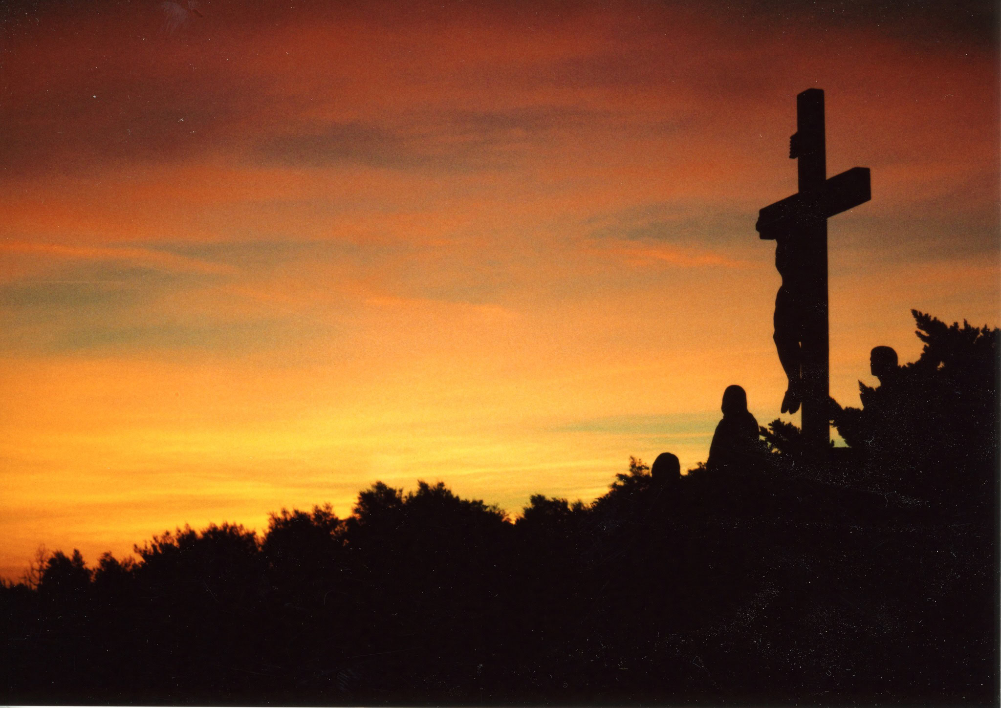 A crucifix silhouetted against a sunset in the foothills of southern california