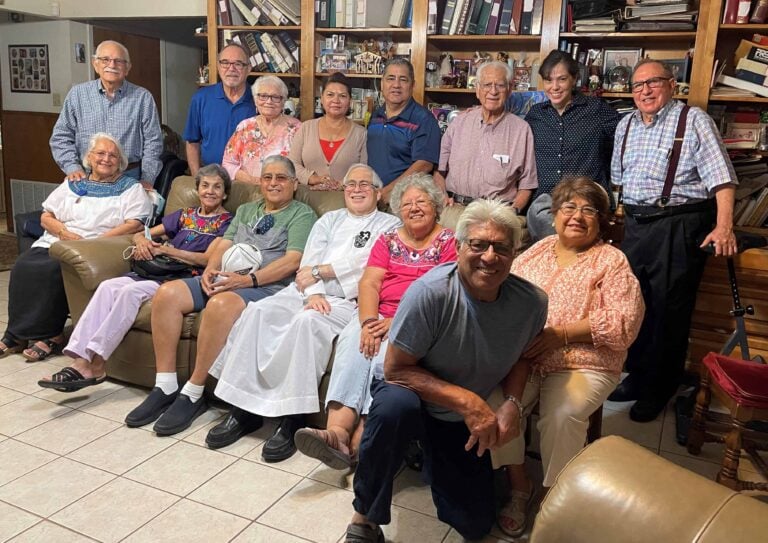 Large group of smiling people with a Passionist priest
