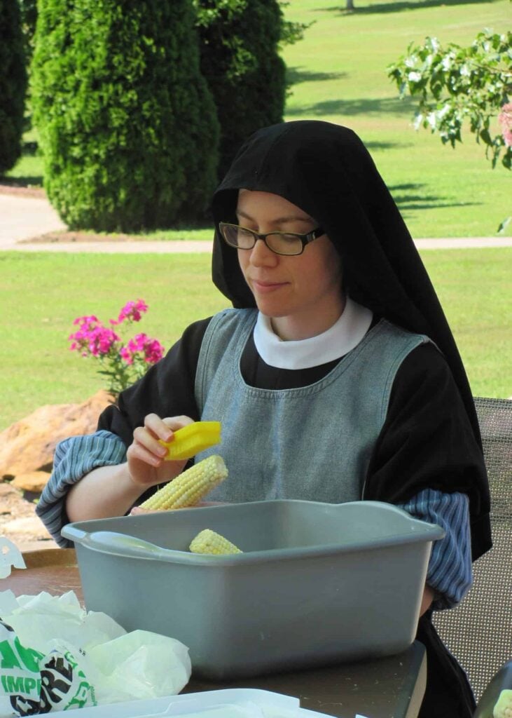 A contemplative Passionist nun tending to corn