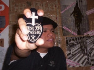 A Passionist priest holds a Passionist sign outward